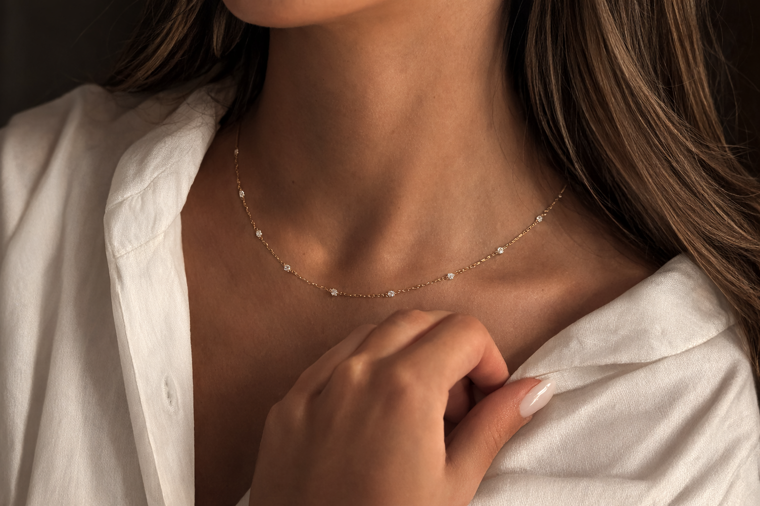 Close-up of a person wearing a delicate gold necklace with a soft focus on the background.